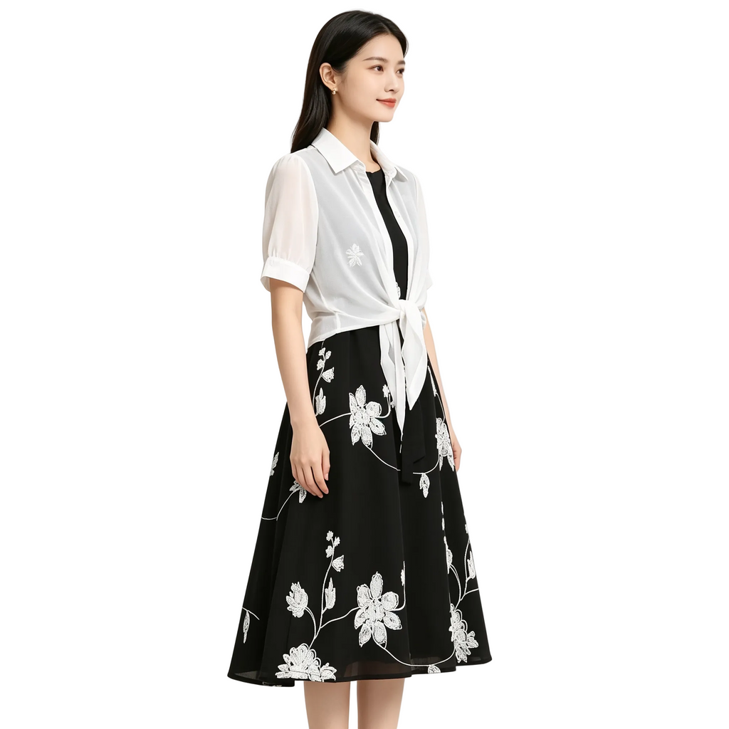 Woman wearing a black floral dress with a white shirt over it on a white background
