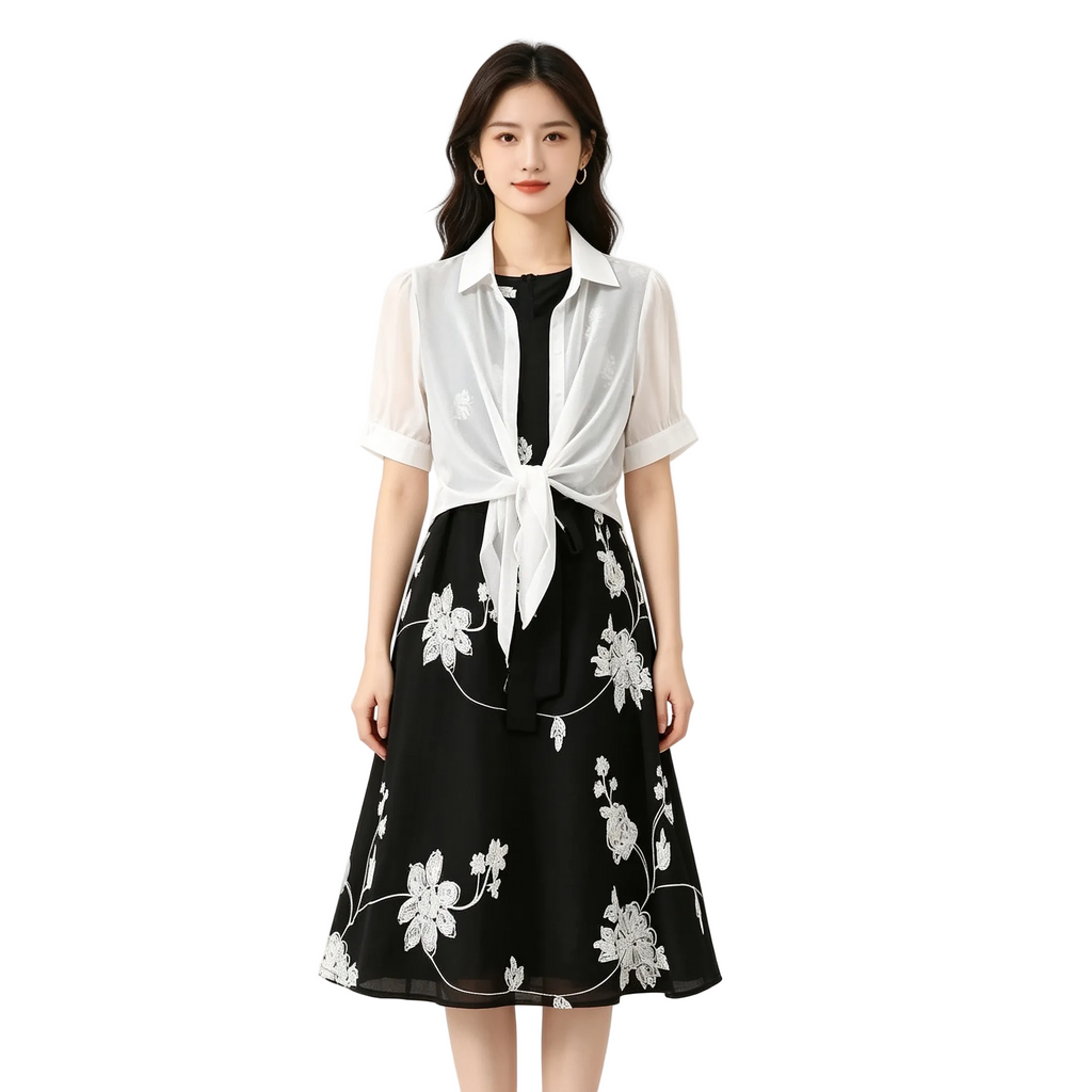 Woman wearing a black floral dress with a white shirt over it on a white background