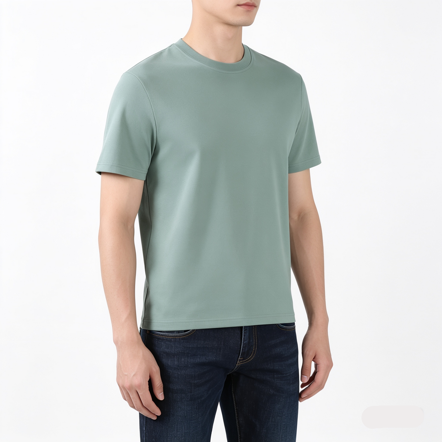 Person wearing a light green t-shirt and dark jeans on a white background
