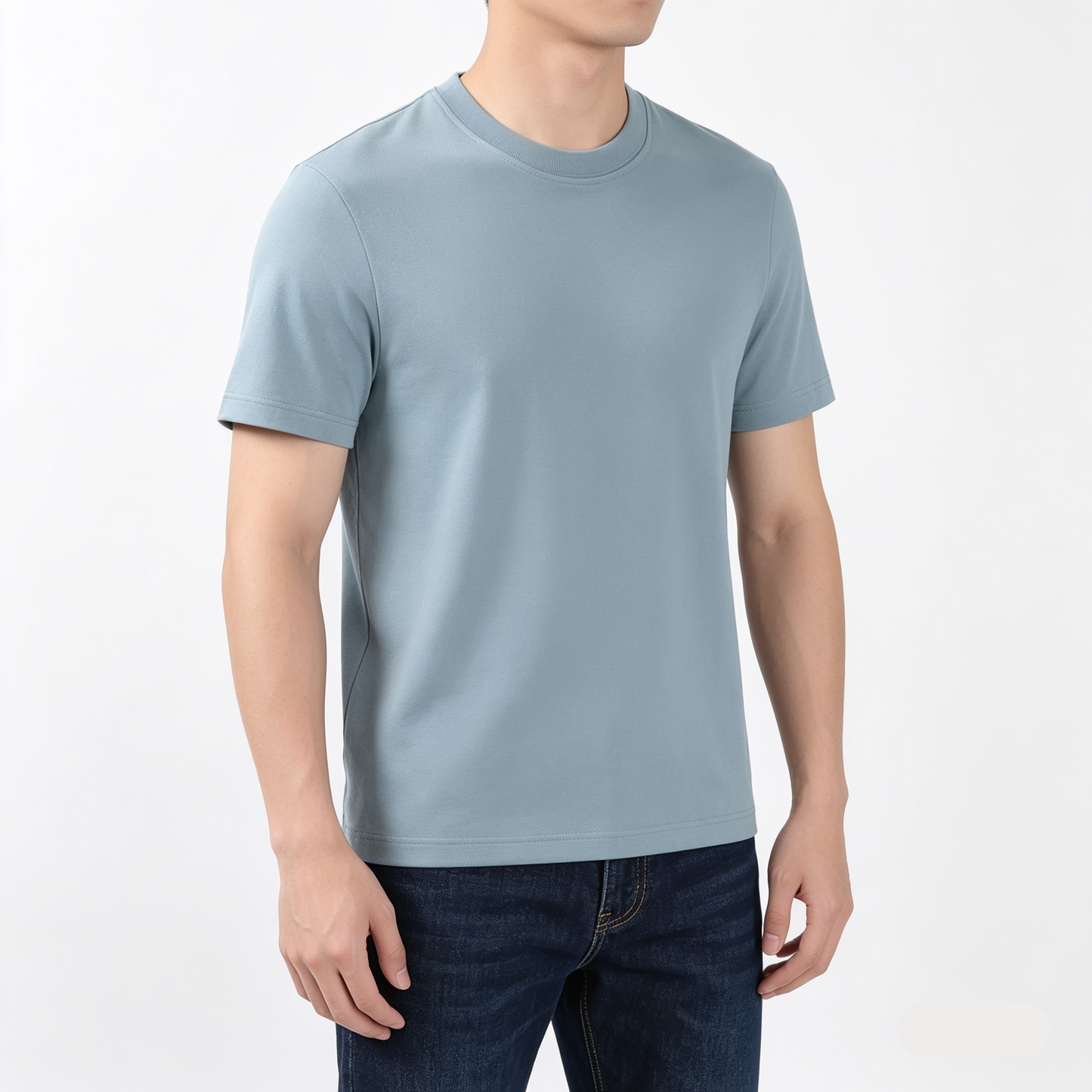Person wearing a light blue t-shirt and dark jeans on a white background