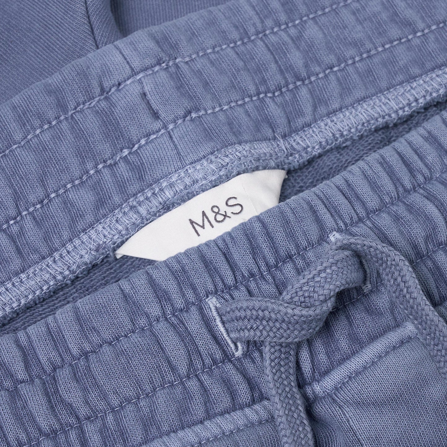 Close-up of blue textured fabric with a M&S label