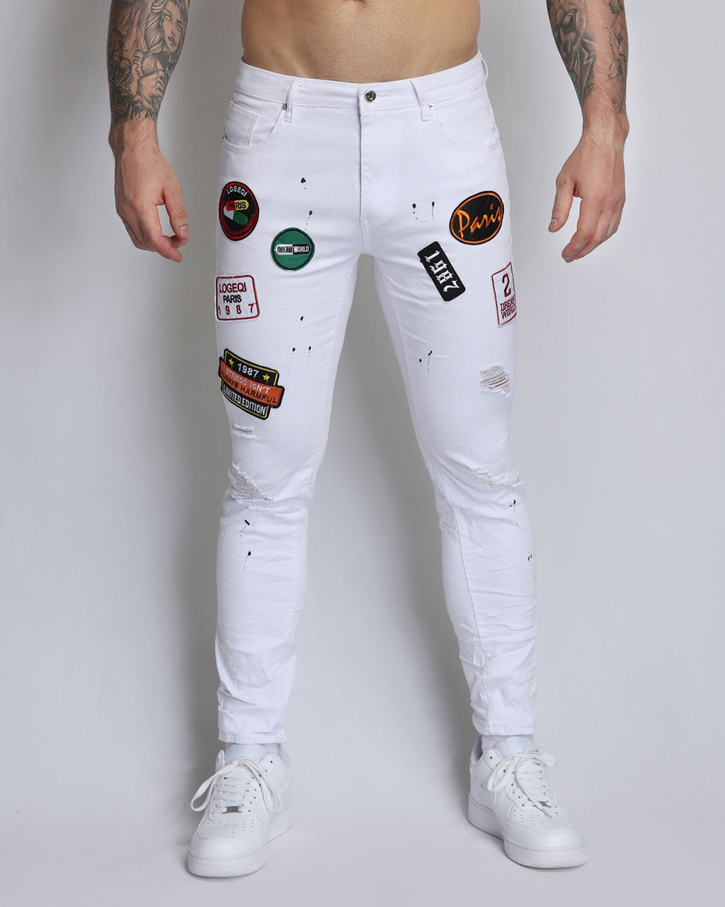 White Ripped Jeans with Badge and Black Spray Paint