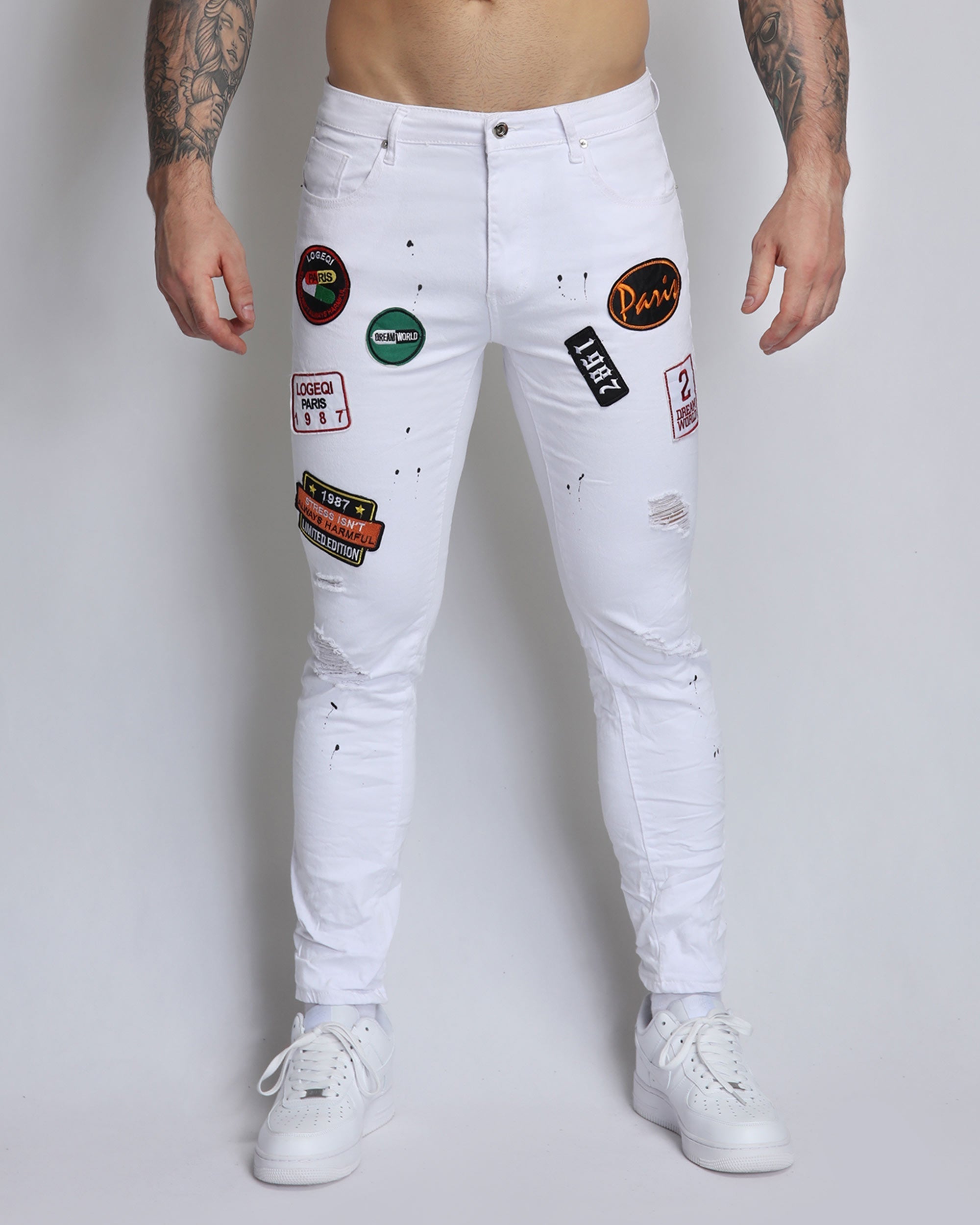 White Ripped Jeans with Badge and Black Spray Paint