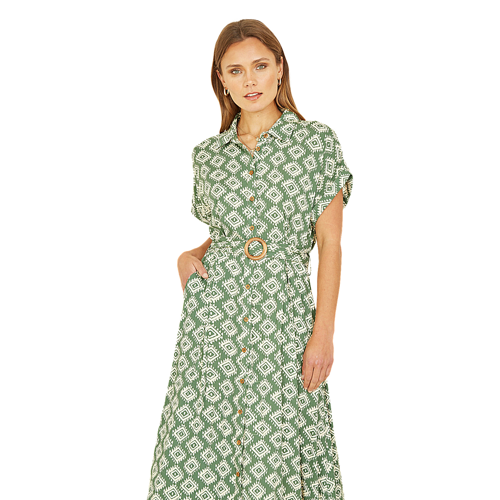 Woman wearing a green patterned dress on a white background