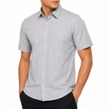Man wearing a gray short-sleeve button-up shirt on a white background