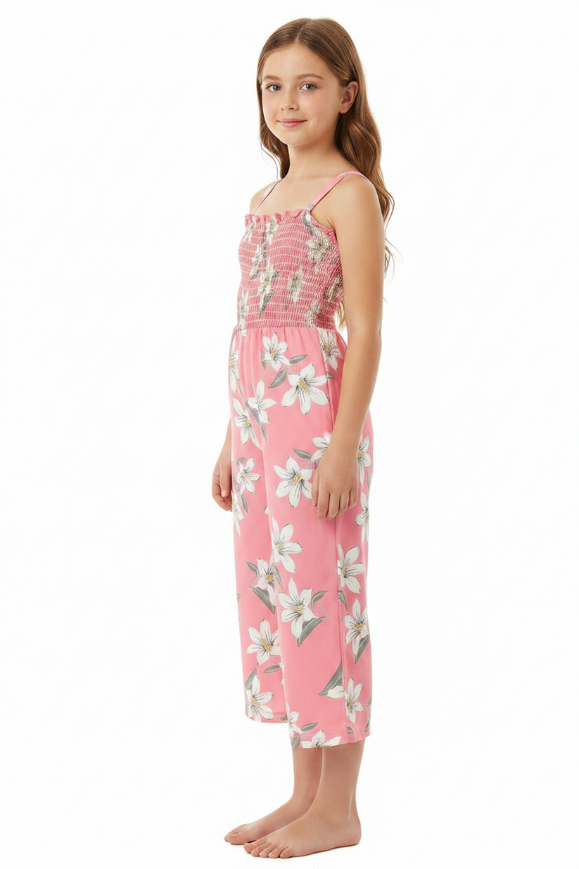 A young girl modeling a pink floral nightgown with white lilies, standing against a plain white background.