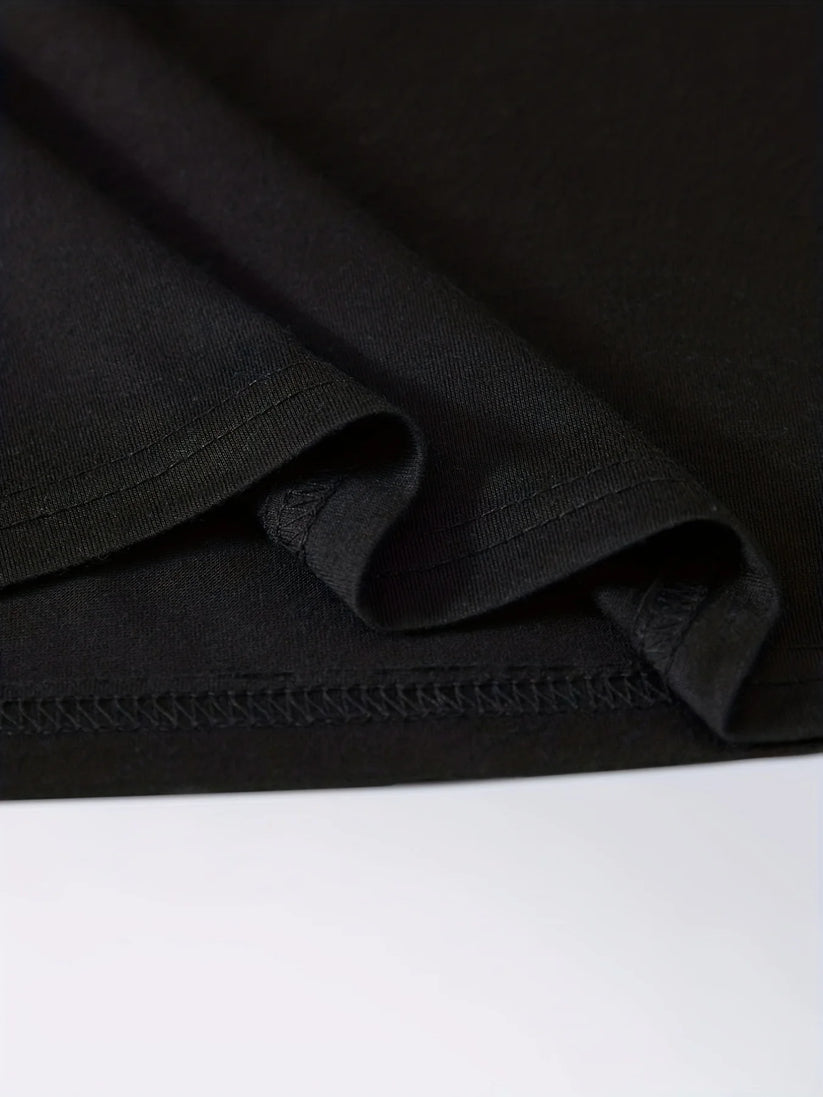 Close-up of a black fabric garment, showing a folded hem with neat stitching on a white surface.