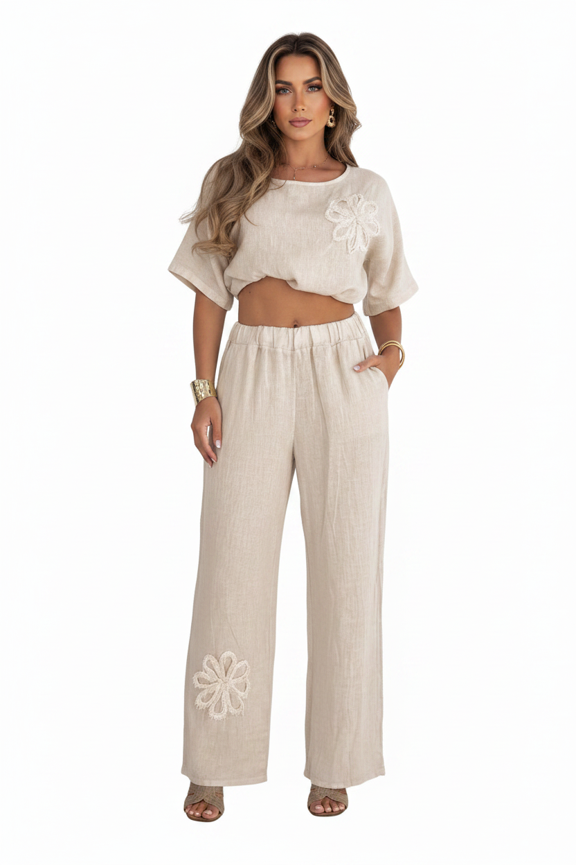 Woman wearing a beige outfit with floral embroidery on a white background
