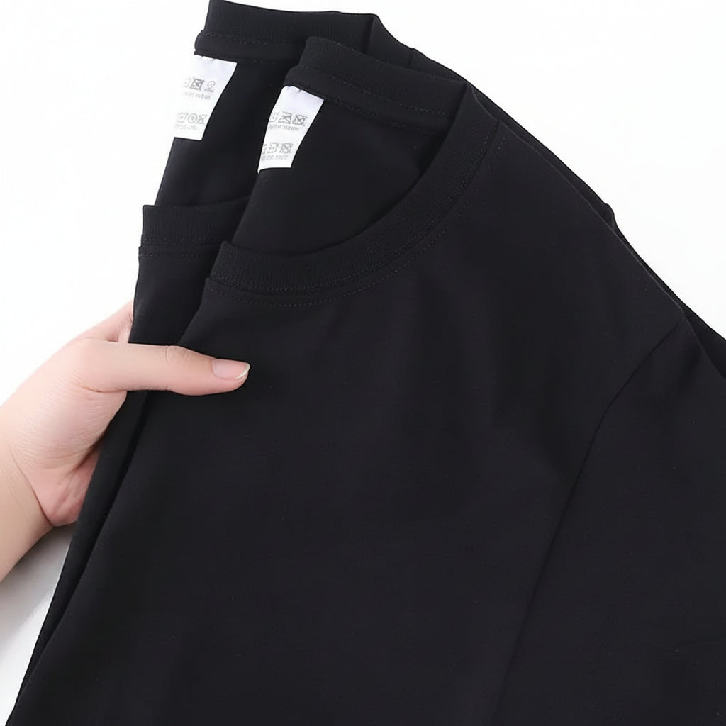 Black shirt with a hand holding it, showing a label and text on a white background