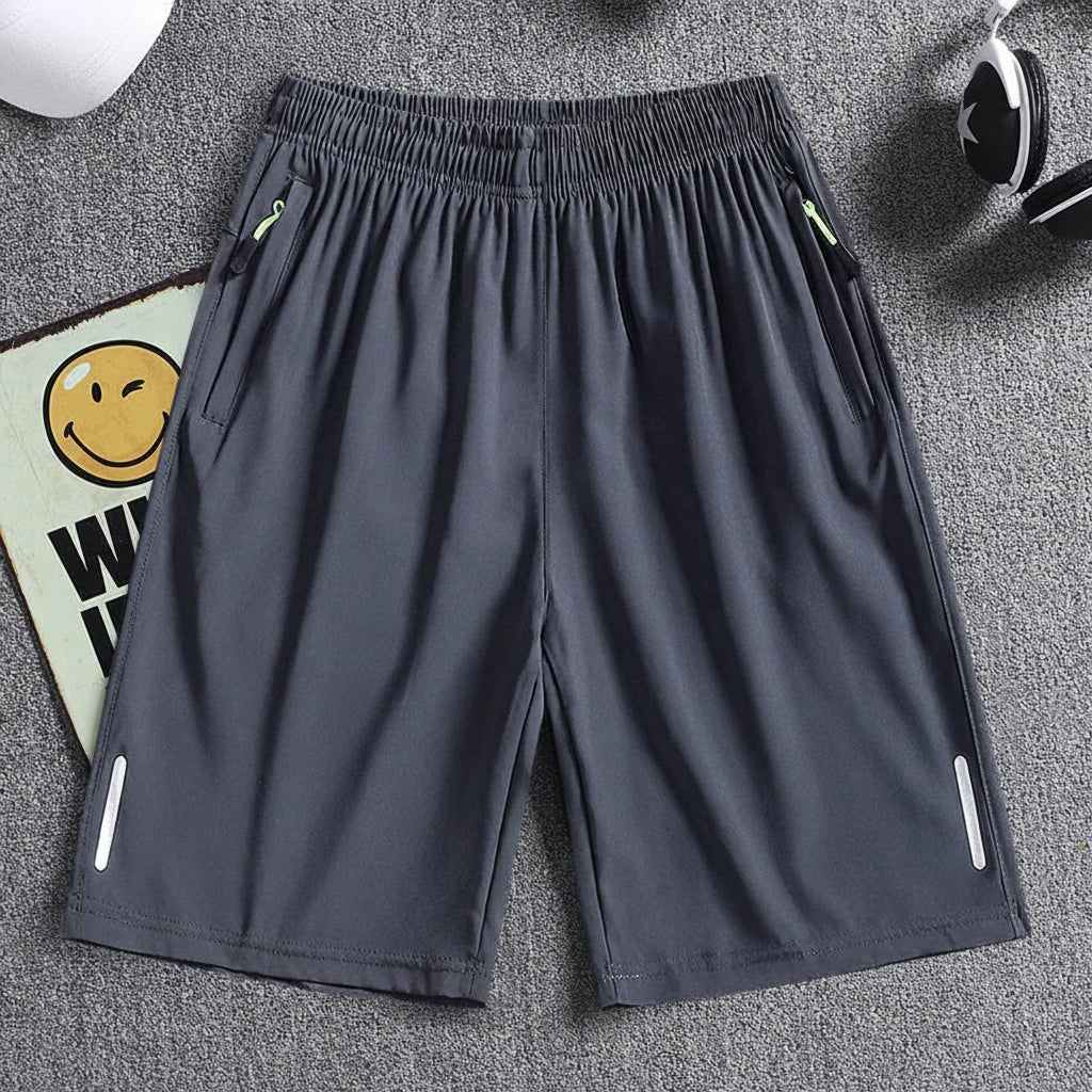 Gray shorts with zippers on a gray background, featuring the brand 'MANTLCONX'.