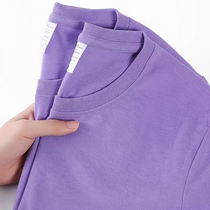 Purple t-shirt with a hand holding it, showing a label on a white background.