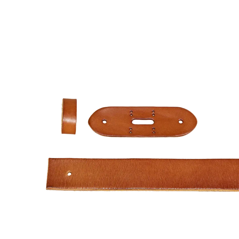 A set of warm brown leather crafting or sewing components, including a long flat strip, an oval center piece with pre-drilled holes, and a small looped piece, arranged on a solid beige background.