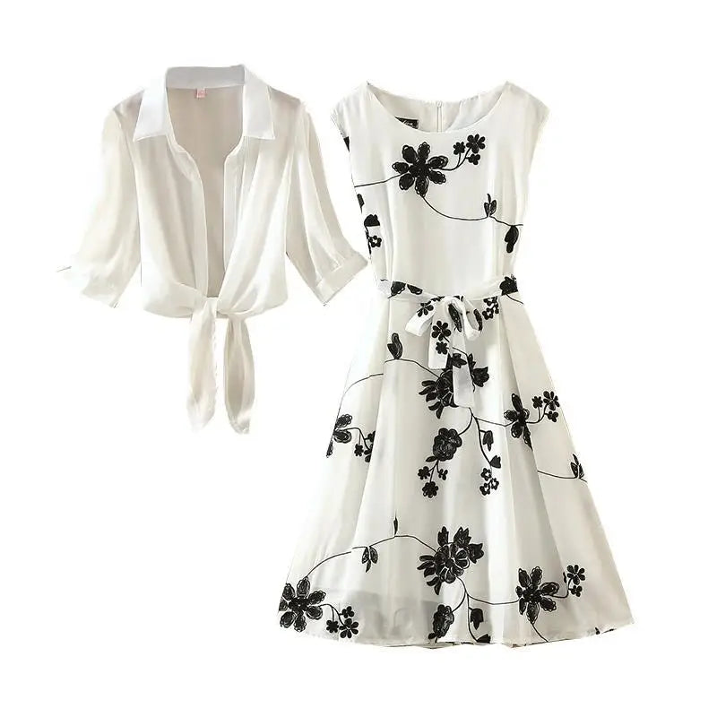 White dress with black floral patterns and a matching white cardigan on a white background