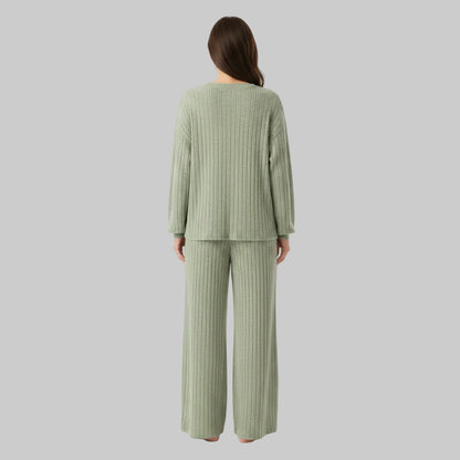 Person wearing a ribbed knit suit in a room with decorative elements.