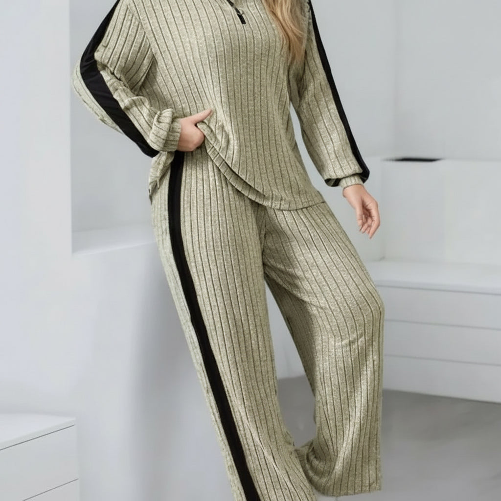 Person wearing a ribbed knit suit with black accents against a white background