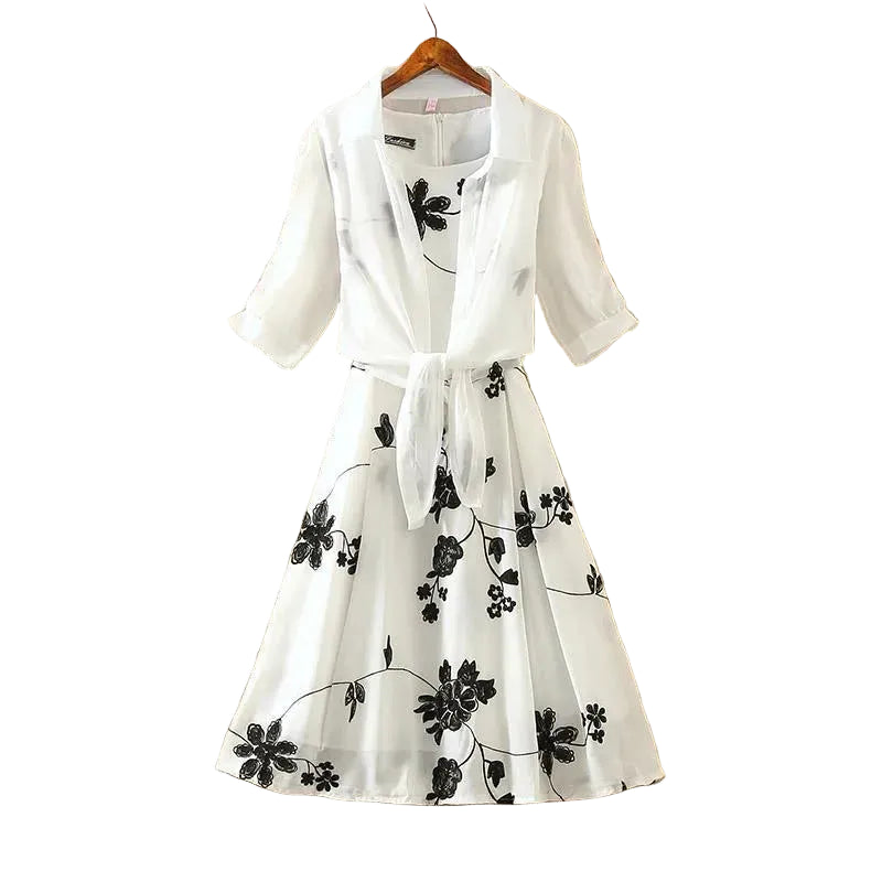 White dress with black floral patterns on a beige wall