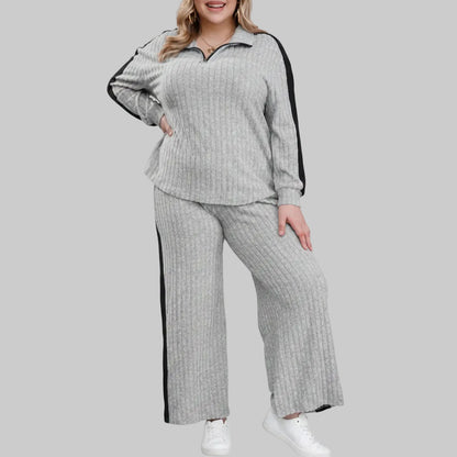 Woman wearing a gray ribbed lounge set with black trim on a white background
