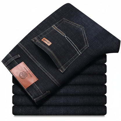 Stack of folded dark blue jeans with a brand label on a white background