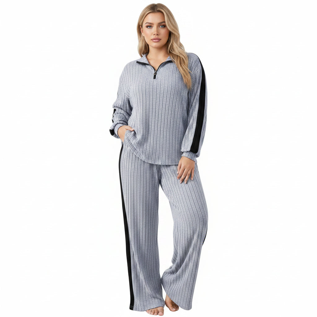 Person wearing a gray and black striped outfit in a minimalistic setting