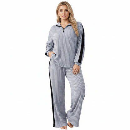 Person wearing a gray and black striped outfit in a minimalistic setting