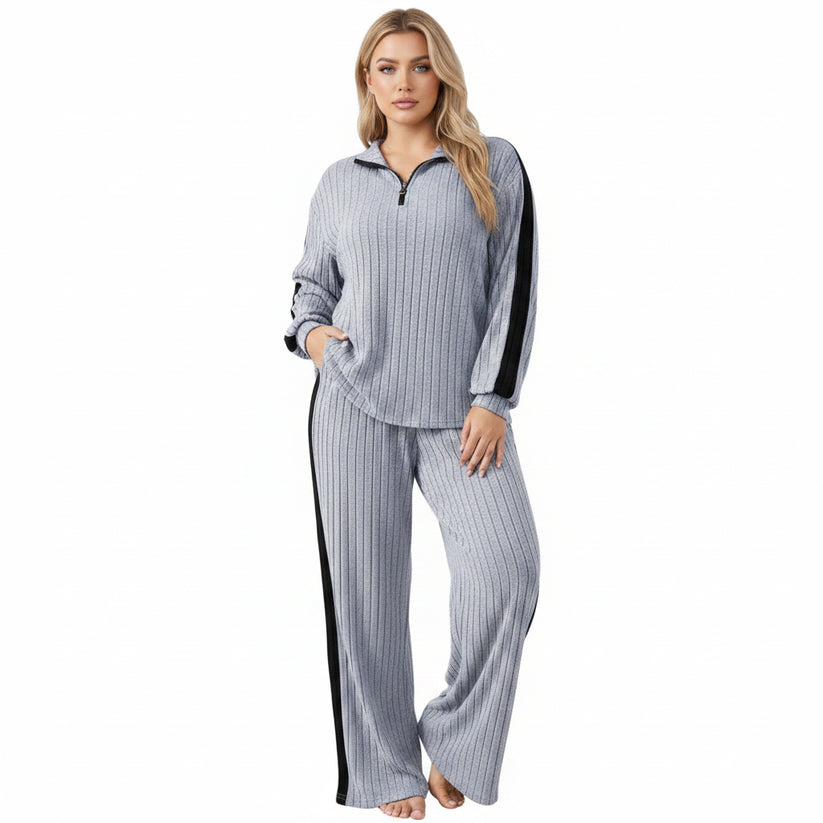 Person wearing a gray and black striped outfit in a minimalistic setting