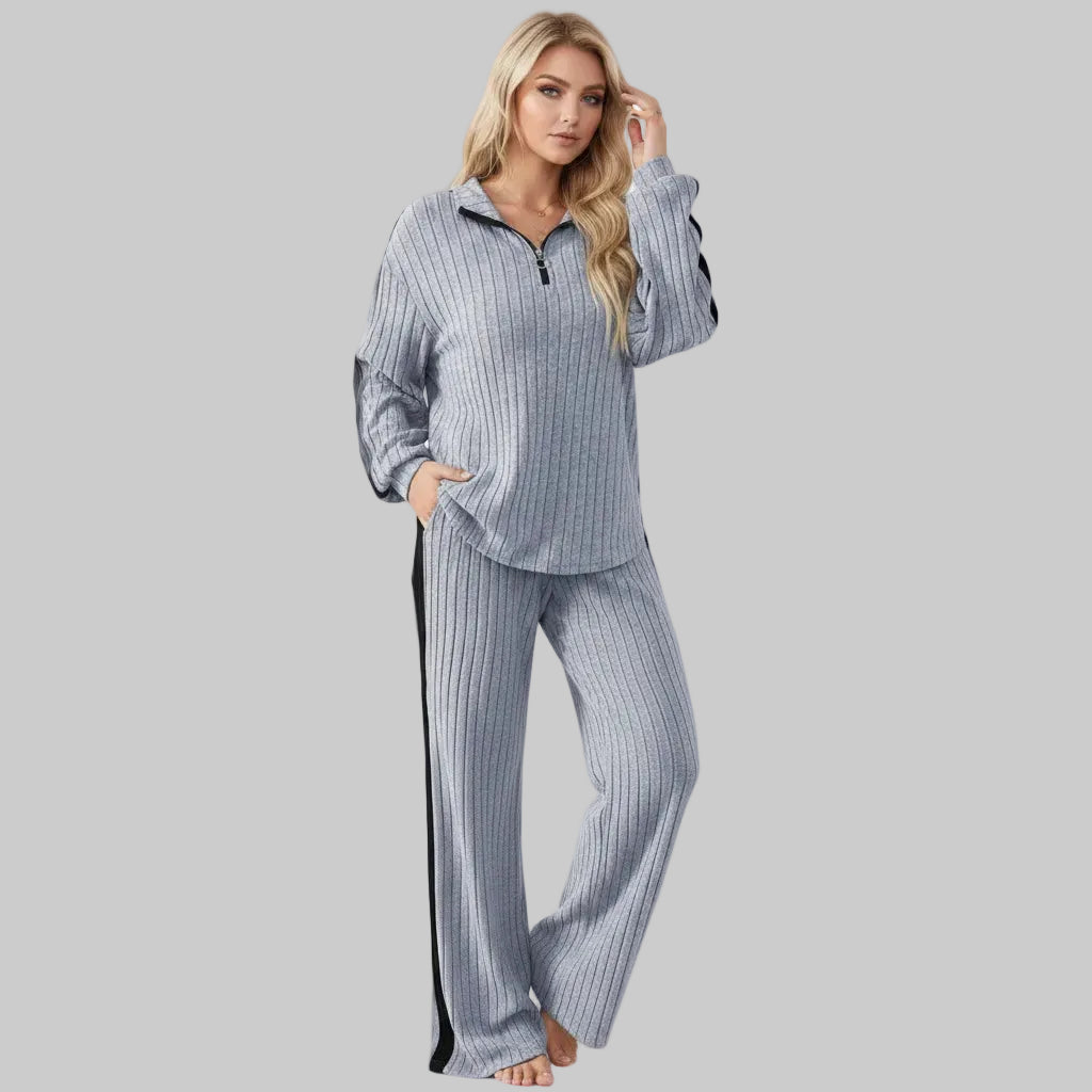 Woman wearing a ribbed gray tracksuit against a white background