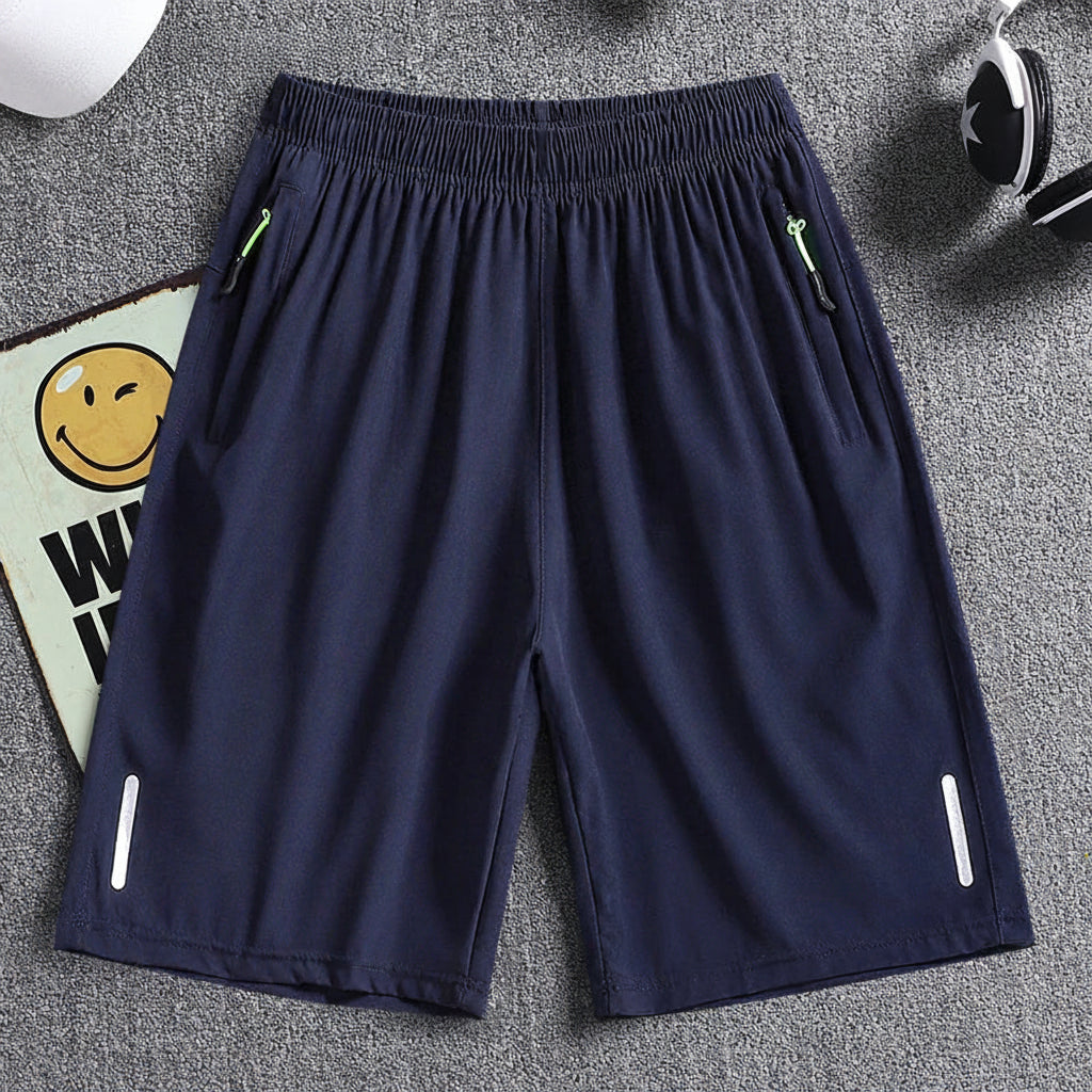 Navy blue shorts with white zippers on a gray surface, featuring the brand 'MANTLCONX'.