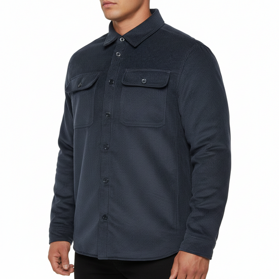 A man wearing a dark navy textured long-sleeve button-up shirt with two buttoned chest pockets, shown from the neck down against a plain white background.